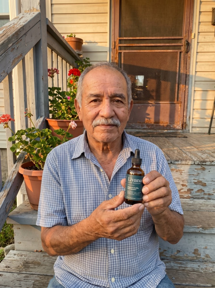 Ray holding his bottle of Livana on the porch steps