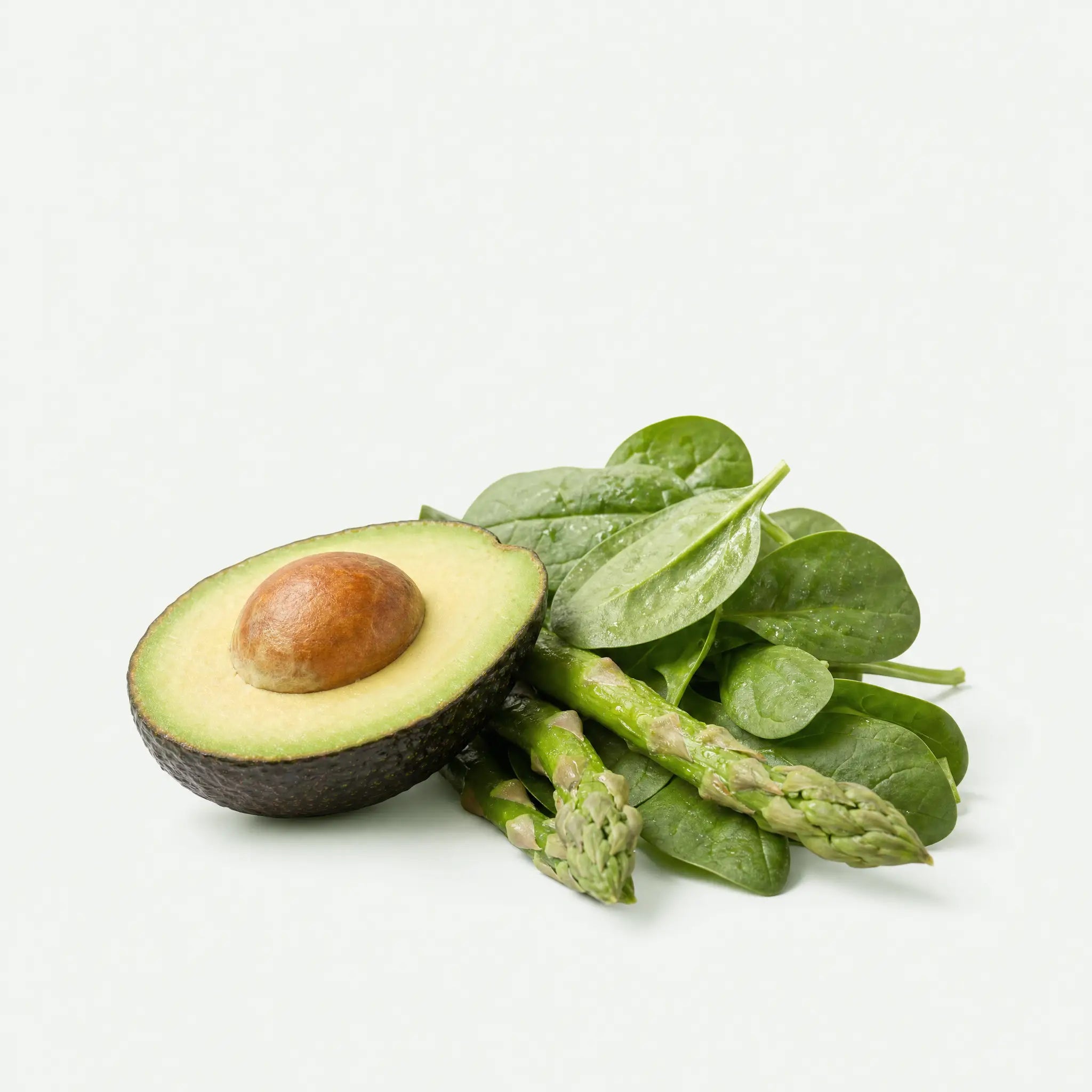 Glutathione-rich foods: halved avocado, spinach leaves, and asparagus