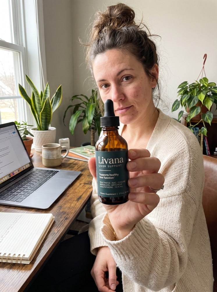 Hannah holding Livana at her home-office desk